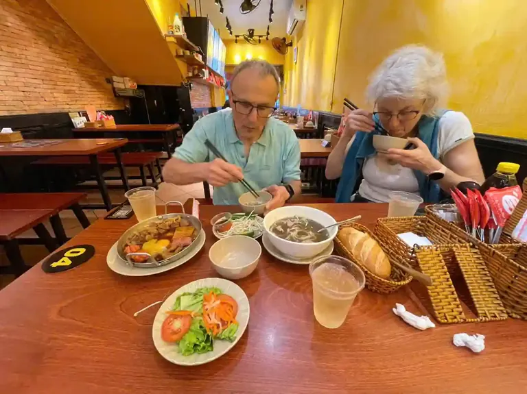 International visitors enjoying traditional Vietnamese pho for breakfast in Saigon